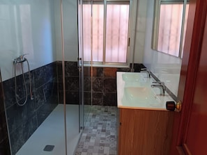 A bathroom with a shower, two sinks, a mirror, and a window with curtains. - Dorm 2 between Trega and Minho A GUARDA (A Guarda)