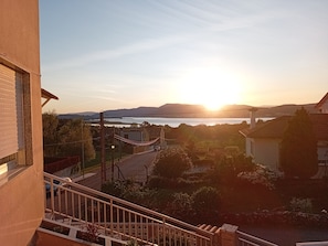 A residential area with a view of the sunset over a body of water, a street, and some greenery. - Dorm 2 between Trega and Minho A GUARDA (A Guarda)