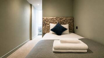 A hotel room with a bed, a nightstand, a window, and a view of the outdoors.