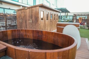 A wooden hot tub with a wooden cabinet in the background. - Southall &Soul (Hayes)