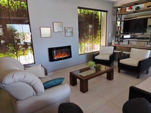 A living room with a fireplace, a sofa, a coffee table, and a TV.