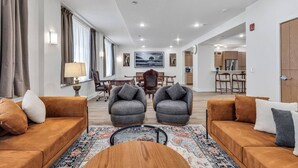 A modern living room with two sofas, a coffee table, and a dining area with chairs. - Downtown Indy-Entire Building-77 Guests (Indianapolis)