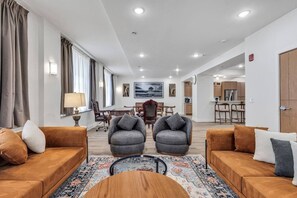 A modern living room with two sofas, a coffee table, and a dining area with chairs.