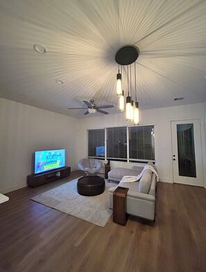 A living room with a flat-screen TV, a ceiling fan, and pendant lights. - Conveniently located Spacious Houston Heights Home-King Suite-Sleeps 6 (Houston)
