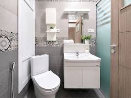 Un baño moderno con inodoro, lavamanos y ducha.