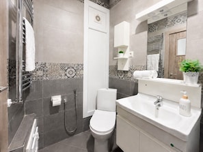 Un baño moderno con inodoro, ducha y lavamanos.