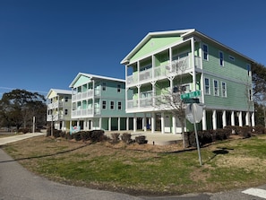A two-story building with a green facade, white balconies, and a street sign indicating '19th Ave S.' - Whole Townhouse with Ocean View and only a 2-minute walk to the Beach! (Myrtle Beach)