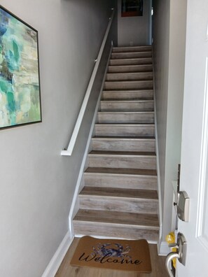 A staircase with wooden steps and a white handrail, leading to a door with a doormat that reads 'Welcome.' - Whole Townhouse with Ocean View and only a 2-minute walk to the Beach! (Myrtle Beach)