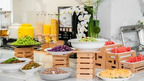 A buffet with various dishes arranged on wooden stands. - Fu Hua Jun Yue Hotel (Luntai County)
