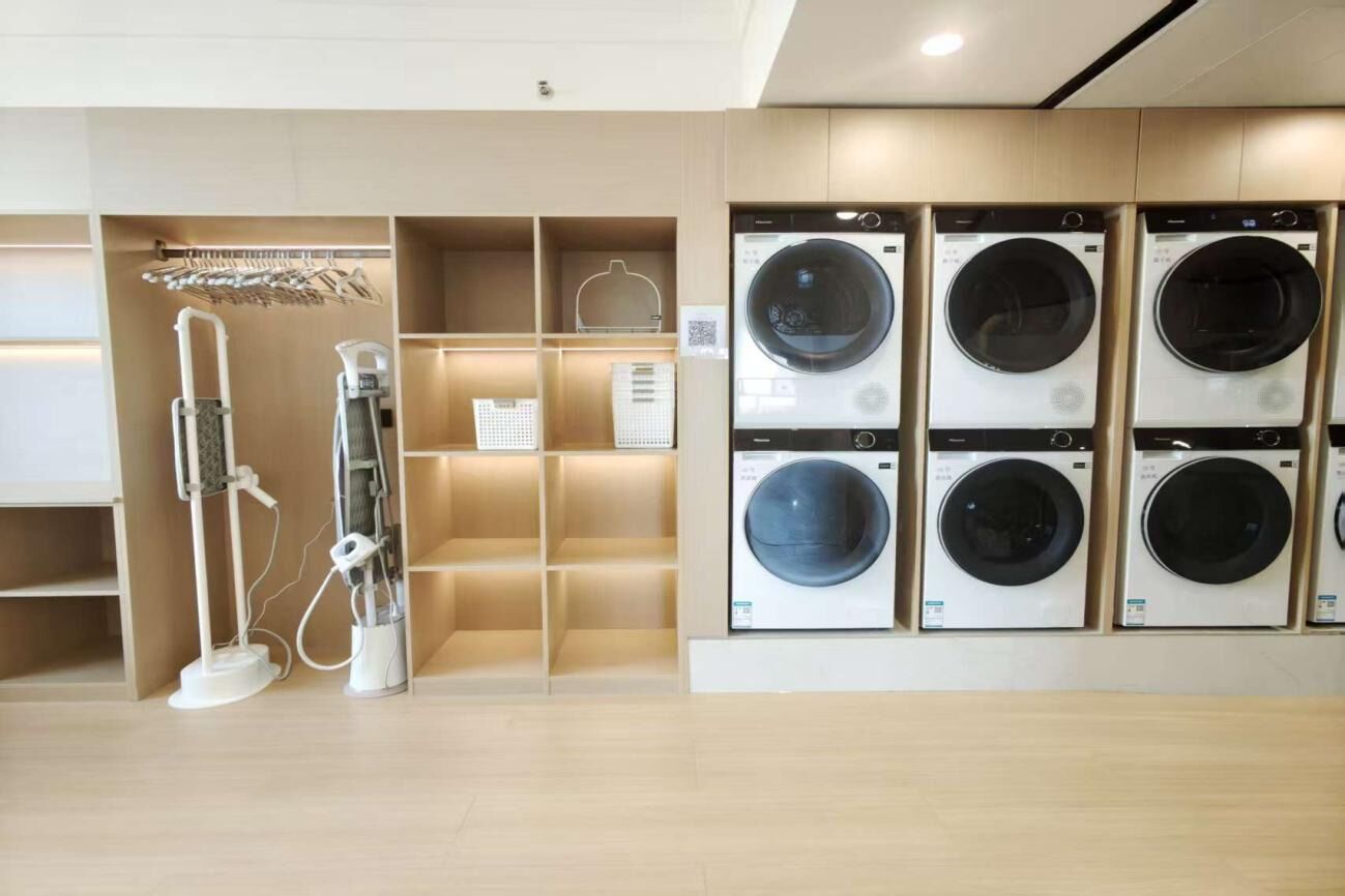 Un cuarto de lavandería con varias lavadoras y una secadora.