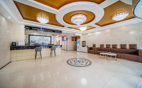 A hotel lobby with a reception desk, bar area, seating, and a decorative floor pattern.. Fu Hua Jun Yue Hotel