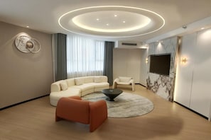 Una sala de estar moderna con un sofá seccional, una mesa de centro y un televisor montado en la pared.