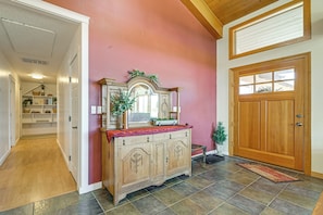 A hallway with a wooden cabinet, a door, and a small plant. - Private Mtn-view Pool! Rogue River Valley Escape (Eagle Point)