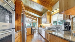 A kitchen with wooden cabinets, stainless steel appliances, and a granite countertop. - Private Mtn-view Pool! Rogue River Valley Escape (Eagle Point)