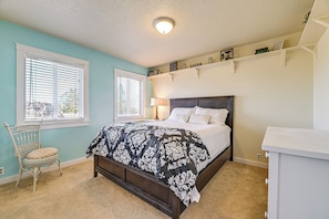 A bedroom with a bed, a chair, a window, and a shelf with books. - Private Mtn-view Pool! Rogue River Valley Escape (Eagle Point)