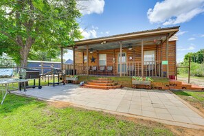A wooden cabin with a porch, outdoor seating, and a barbecue grill. - Cabin w/ Dock on Hubbard Creek Lake: Pets Welcome! (Breckenridge)