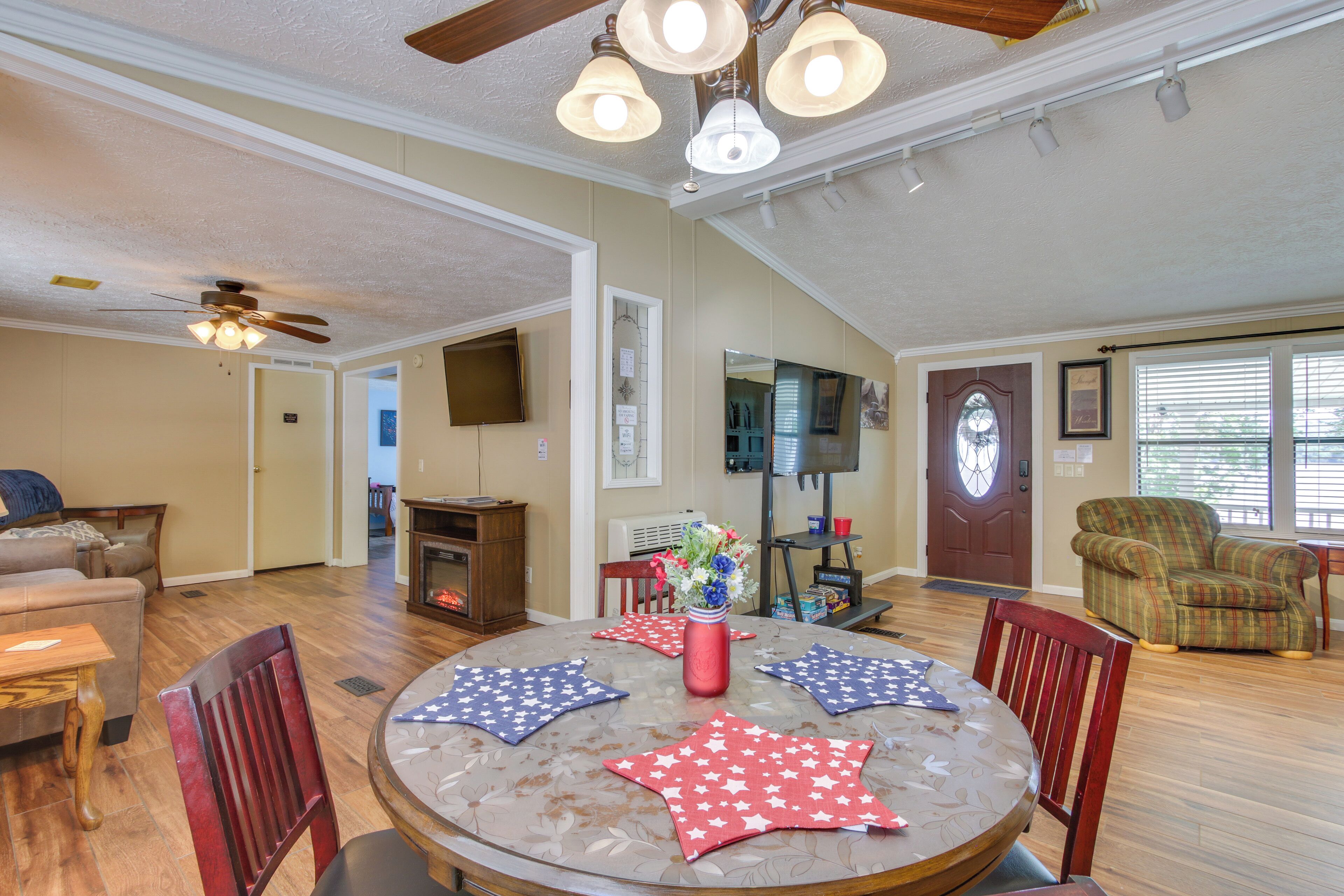 A spacious living room with a round table, chairs, a fireplace, and a television.