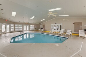 An indoor swimming pool with ceiling fans, white lounge chairs, and large windows. - Pool Access & 2 Mi to Beach! Ocean City Escape (Ocean City)