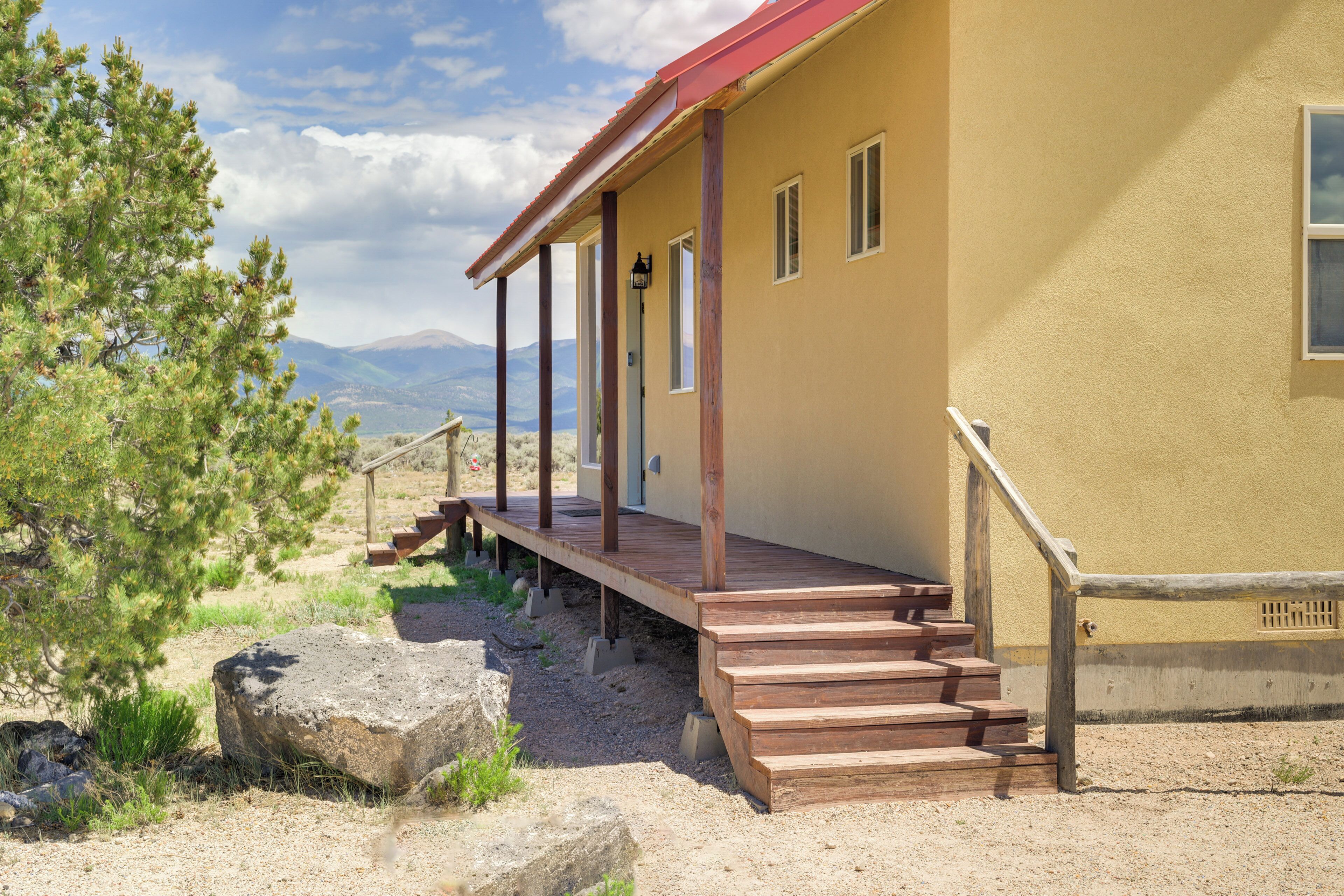 A building with a wooden porch and steps leading to a door.