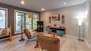 Een moderne woonkamer met een bank, salontafel, vloerlamp en een boekenkast.