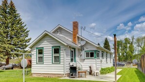 A single-story house with a chimney, a satellite dish, and a small porch with a table and chairs.