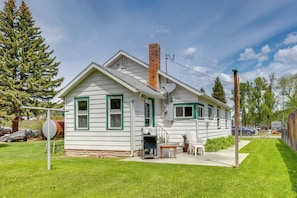 A single-story house with a chimney, a satellite dish, and a small porch with a table and chairs.