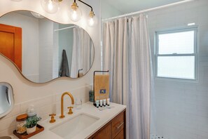 A bathroom with a white sink, gold faucet, and a towel rack with a towel.