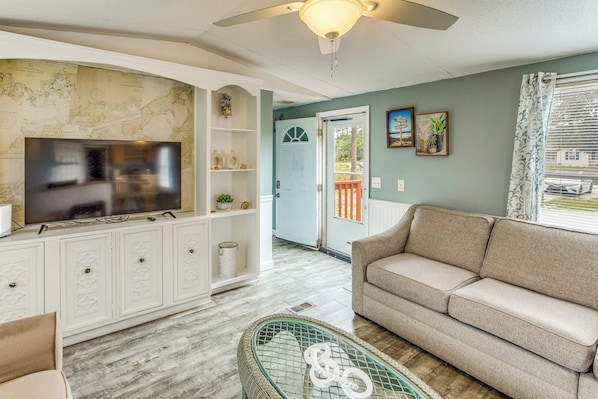 A living room with a TV, sofa, and decorative items.