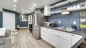 Een moderne keuken met witte kasten, roestvrijstalen apparatuur en een ingebouwde oven.