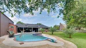 A backyard with a swimming pool, a covered patio, and a fenced yard. - Pool & Covered Patio! Galveston County Getaway (Dickinson)