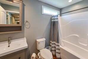 Une salle de bain avec des toilettes, un lavabo et une baignoire.