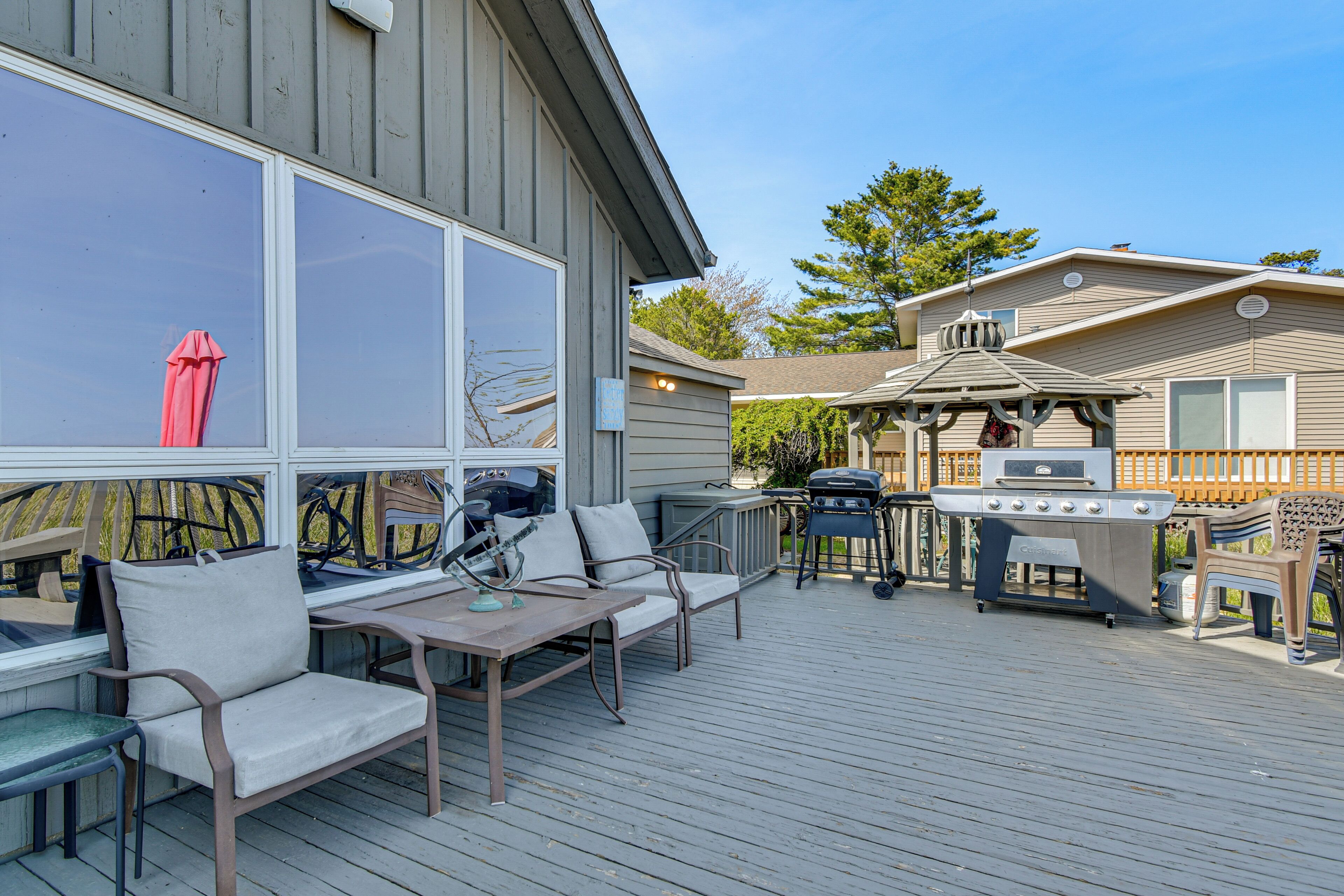 A deck with outdoor furniture, a grill, and a covered area.