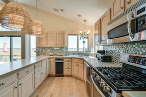 A kitchen with wooden cabinets, a stainless steel stove, a microwave, and a dishwasher.