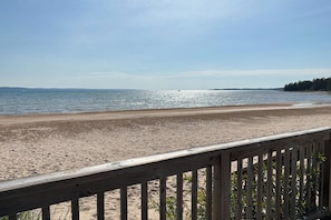 A beach with a wooden deck in the foreground.