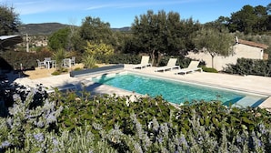 A rectangular pool with lounge chairs, surrounded by greenery and a clear sky. - Spacious 5-bedroom house with AC and Pool (Le Plan-de-la-Tour)