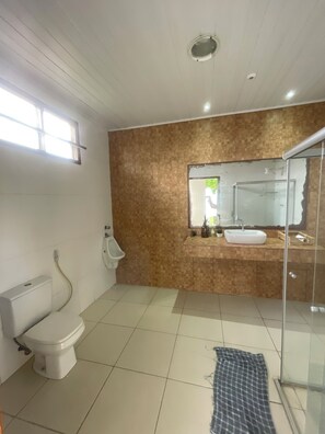 Un bany modern amb vàter, bidet i cabina de dutxa de vidre.