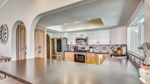 A kitchen with white cabinets, stainless steel appliances, and a large island. - 2 Mi to Windsor Boat Launch! Lake-view Escape (Lake Havasu City)