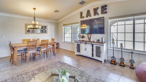 A spacious dining area with a wooden table and chairs, a chandelier, and a large window with a view. - 2 Mi to Windsor Boat Launch! Lake-view Escape (Lake Havasu City)