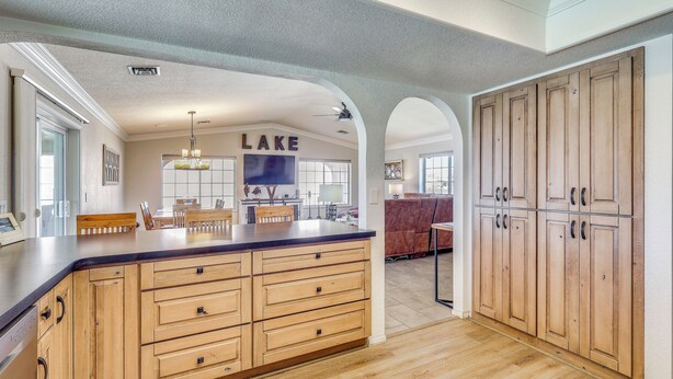A kitchen with wooden cabinets, a large island, and a ceiling fan. - 2 Mi to Windsor Boat Launch! Lake-view Escape (Lake Havasu City)