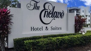 A sign for 'The Enclave Hotel & Suites' with a modern building in the background. - 2 Miles to Universal - Lake View -Sleeps 6 (Orlando)