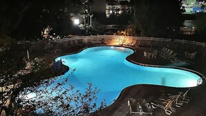 A swimming pool with a curved edge, surrounded by a white fence and lounge chairs. - 2 Miles to Universal - Lake View -Sleeps 6 (Orlando)