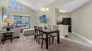 Um apartamento moderno com área de jantar, cozinha e sala de estar.