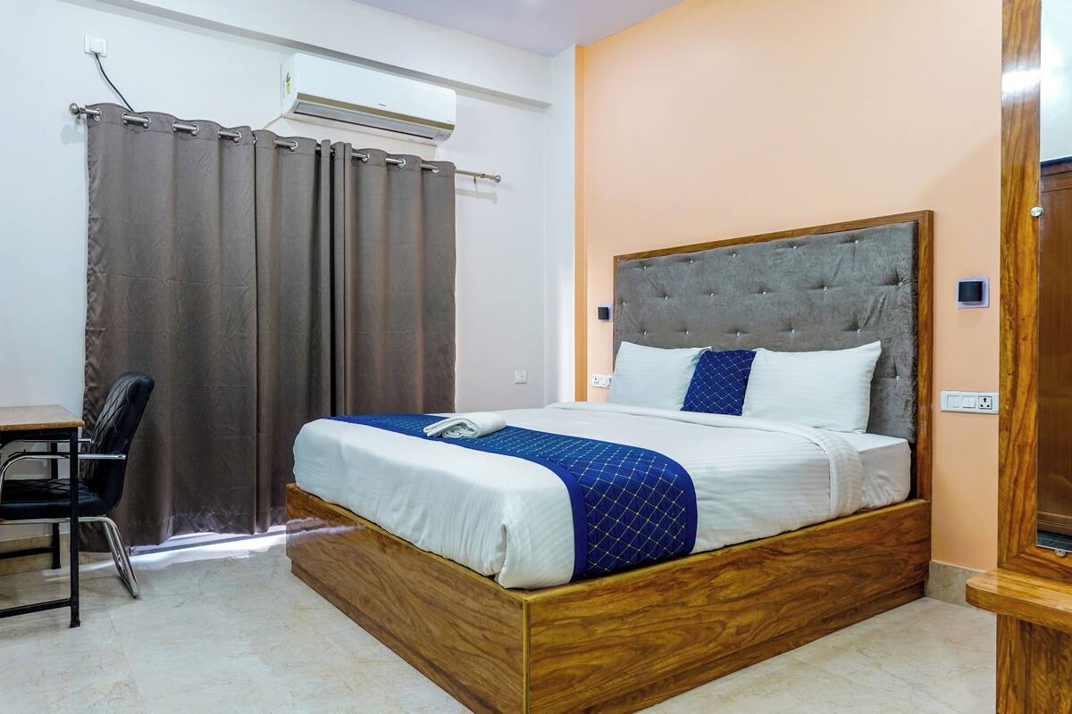 Un dormitorio con una cama de madera, un escritorio y una silla.