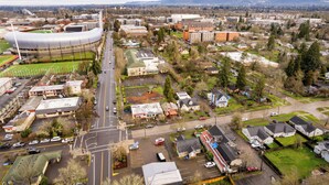 An aerial view of a cityscape with a stadium, residential areas, and commercial buildings. - Hayward Field Studio. In the heart of Tracktown USA. (Eugene)