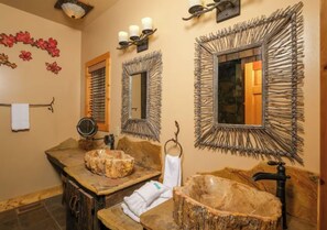 A bathroom with a rustic design, including a wooden vanity, a large mirror with a twig frame, and a stone basin. - Riversong Retreat | Pet-Friendly Gatlinburg Cabin with Mountain Views & Game Roo (Sevierville)