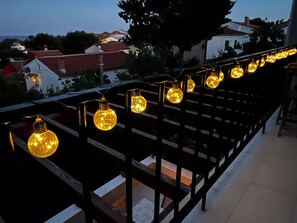 Ein Balkon mit einer Reihe von kugelförmigen Leuchten.