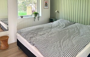 A bedroom with a bed, a window with a view, a bedside table, and a wall-mounted lamp. - Gorgeous home in Hurup Thy with WiFi (Hurup Thy)