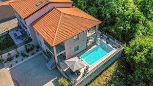 A multi-story building with a swimming pool, outdoor seating, and a garden area. - Beautiful home in Nova Vas (Nova Vas)
