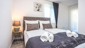 A neatly made bed with a dark headboard, white pillows, and a rolled towel on the bed. - Beautiful home in Nova Vas (Nova Vas)
