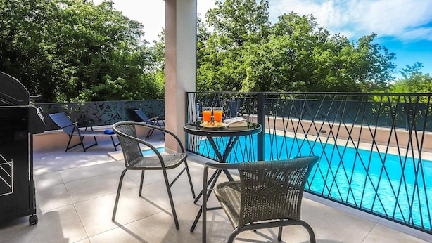 A balcony with a pool, two wicker chairs, a table with drinks, and a grill. - Beautiful home in Nova Vas (Nova Vas)